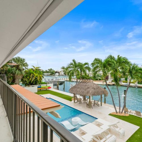 Second-floor balcony overlooking the pool and canal. Morning coffee with a view hits different here.