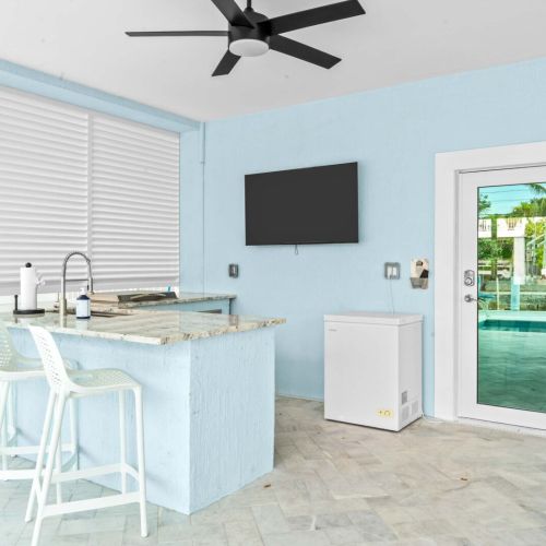 Outdoor bar zone ready for good times by the pool. Watch the game on tv, keep drinks cold in the cooler, and kick back with everyone under the fan-cooled shade.