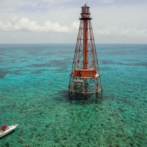 Experience the serene beauty of, where a charming boat glides through the water near a picturesque lighthouse. Discover the perfect blend of relaxation and adventure just steps away from your doorstep.