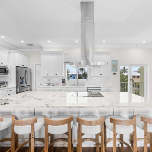 Chef's kitchen: an oversized marble island with six stools and a pro-style hood.