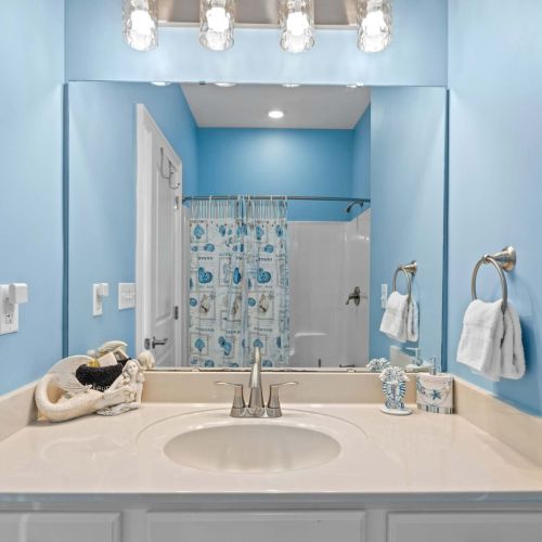 Bright turquoise walls and ocean-themed decor create a refreshing spa-like vibe!