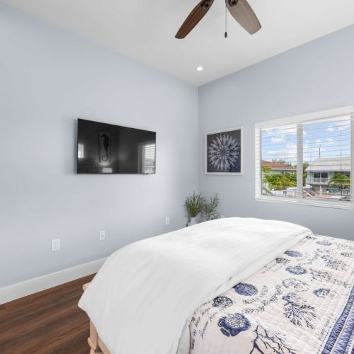 Bedroom 1: soft blue walls and a canal-view window beside the bed.