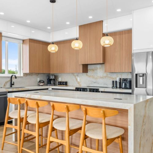 Sleek modern kitchen with waterfall island, stainless appliances, and seating for the whole crew.