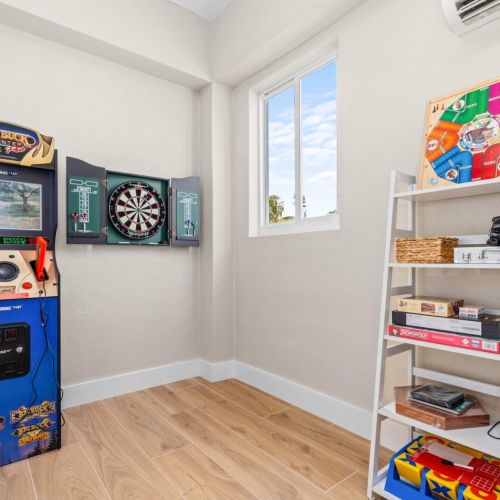 Game room stocked and ready. Arcade machine, darts, and a shelf full of board games for late-night battles and bragging rights.