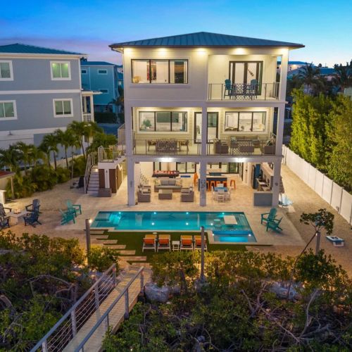 Three waterfront stories with a heated pool, outdoor lounge, and balconies on every level.