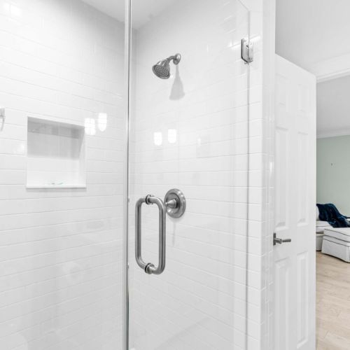 Walk-in shower steps from the primary suite, complete with bright natural light and water views.