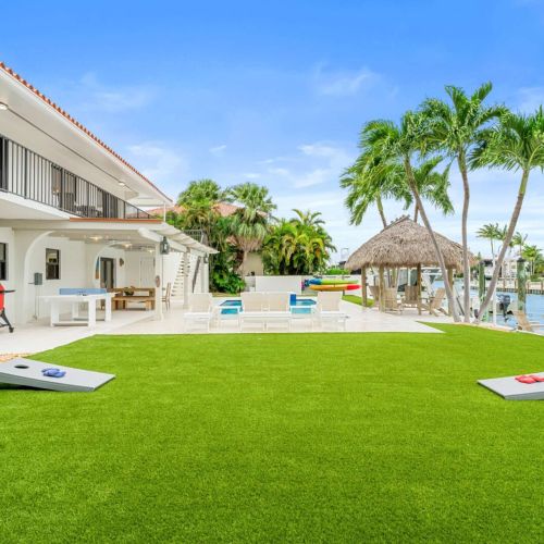 Game-ready backyard with cornhole, palm trees and the pool just steps away.