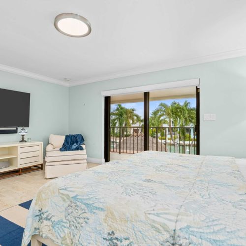 Primary suite with balcony access and palm tree views right from the bed.