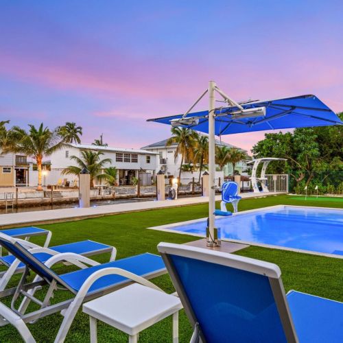 Poolside loungers with canal views at sunset. The perfect spot to slow down and enjoy the evening sky.