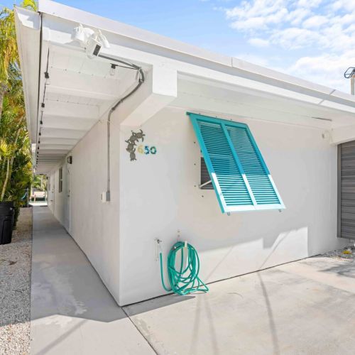 Escape to our charming airbnb where the striking white façade meets vibrant blue windows. Enjoy your stay in this cozy haven surrounded by lush greenery and a clear sky. Perfect for unwinding and making unforgettable memories! Book your getaway today