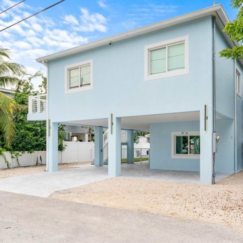 A quiet welcome before the adventure begins. The soft blue exterior and open drive give way to the warmth waiting inside, where calm mornings and sunlit afternoons start with the keys breeze and a sense of ease.