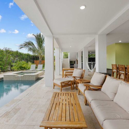 Covered patio: shaded sofas and a dining bar overlooking the water all day long.