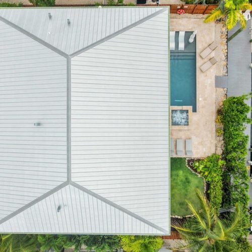 Aerial overhead: pool, spa, dock, and boat lift all lined up along the canal.