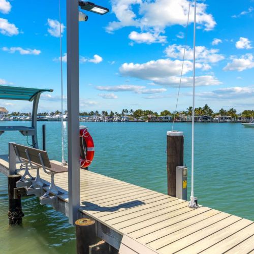 Canopied boat lift, bench seating, lighting, and direct open-water access.
