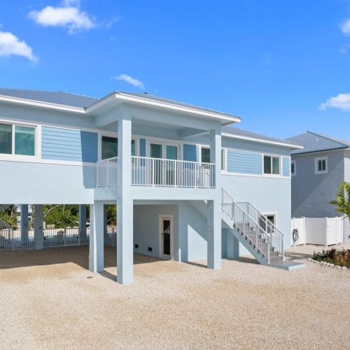 Leave your car under the carport and climb the stairs to reach the open-concept living area.