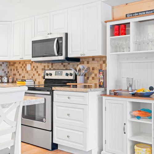 Step into your dream kitchen! With sleek white cabinets and modern appliances, this space is perfect for culinary adventures or cozy dinners.