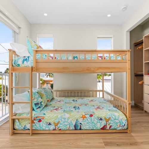 Bright and cheerful bunk room with balcony access and plenty of storage for all your beach gear and vacation essentials.