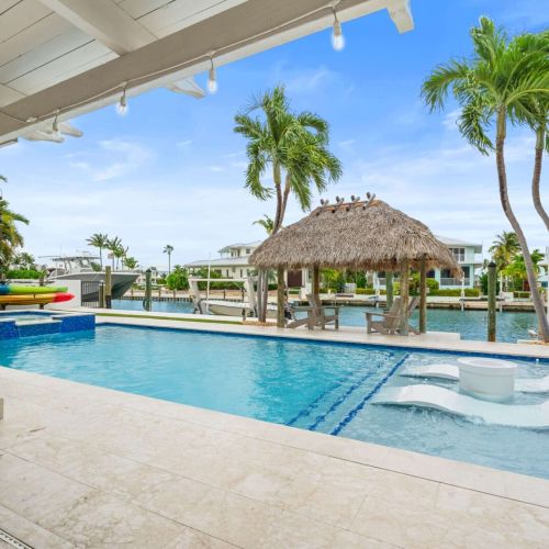 Shaded patio steps from the pool and canal. Chill in the loungers while the breeze rolls in.