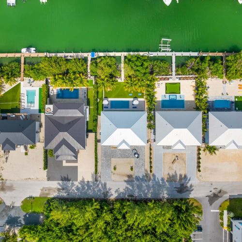 A bird’s-eye view of paradise living. Perfectly placed along the turquoise canal, emerald oasis stands out with its palm-lined backyard, private dock, and sparkling pool—your front-row seat to the laid-back rhythm of the florida keys.