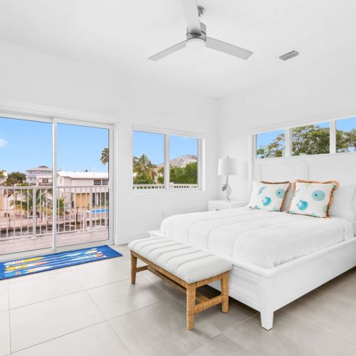 Primary suite with balcony views and natural light from every angle. Wake up to palm trees and sunshine.