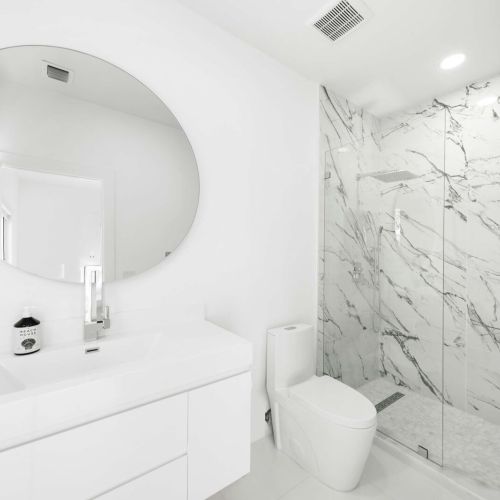 Indulge in luxury with sleek marble finishes and a spacious rain shower experience!