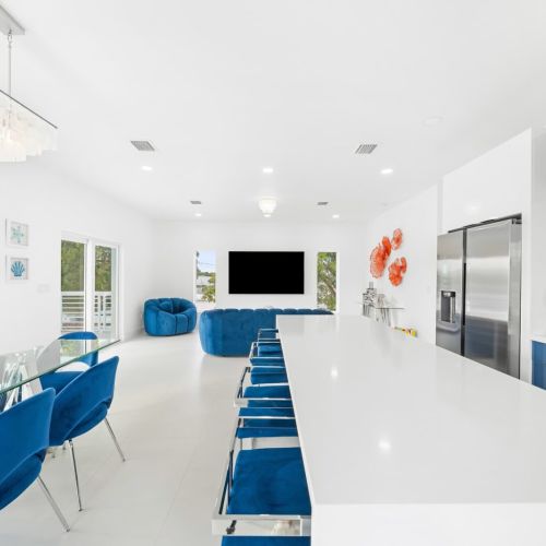 Bright and stylish space with vibrant blue seating and a sleek dining area for gatherings!