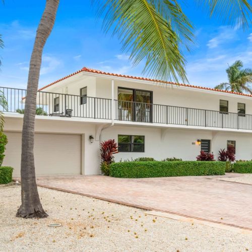 Clean modern exterior with plenty of parking and an inviting wraparound balcony that hints at the views waiting inside.