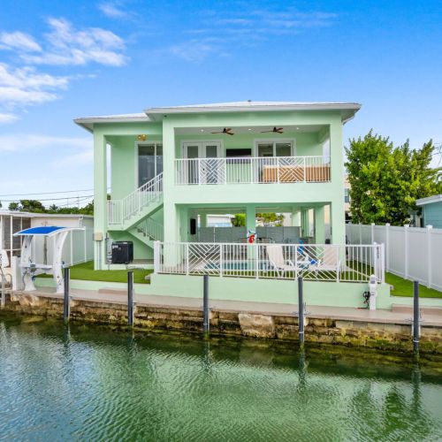 Your stunning modern retreat sits waterfront with private dock, heated pool, and putting green, offering the perfect blend of luxury and island living.