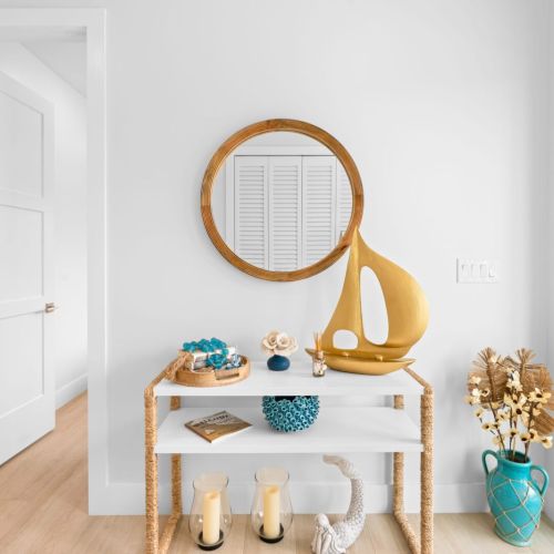 Transform your space with a touch of elegance! This living room features a sleek table and a glamorous mirror.