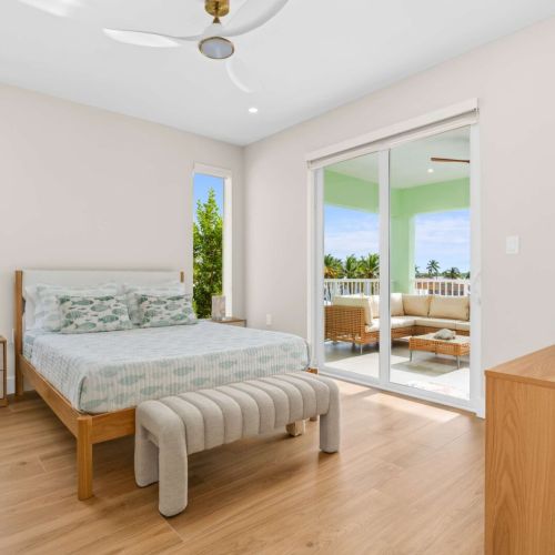 Tranquil bedroom with tropical views and direct access to your private outdoor oasis for seamless indoor-outdoor living.