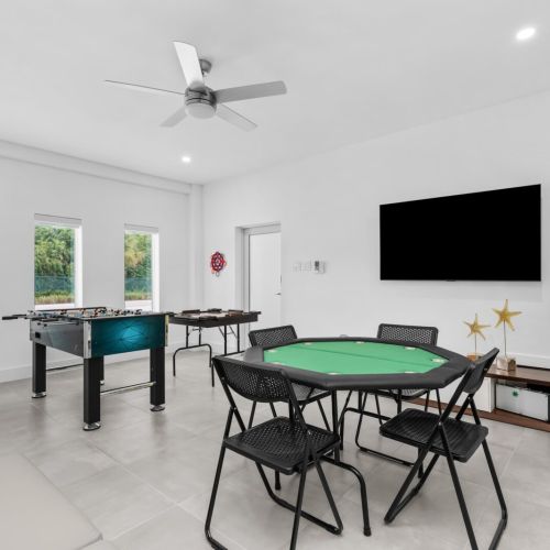 Game room ready for fun with foosball, poker, arcade games, and a big screen for hanging out.