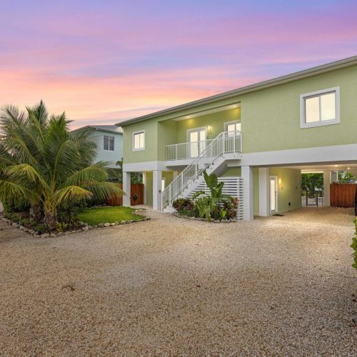 Front entry: palm-lined drive, covered parking, and a gated entry to your retreat.