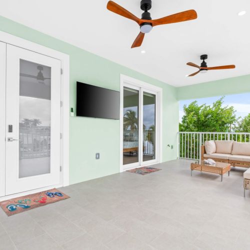 Shaded outdoor lounge with ceiling fans and comfortable seating, your perfect spot to enjoy the tropical breeze and plan the day's adventures.