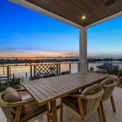A teak table for six under the covered balcony with a front-row sunset view.