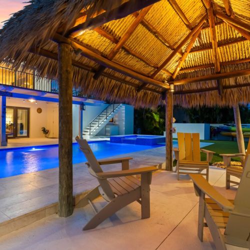 Relax under the tiki hut with drinks in hand while the pool lights glow into the night.