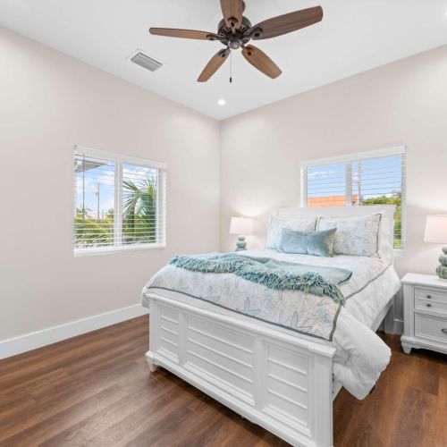 Guest bedroom: a sunny queen room with twin windows and breezy coastal touches.