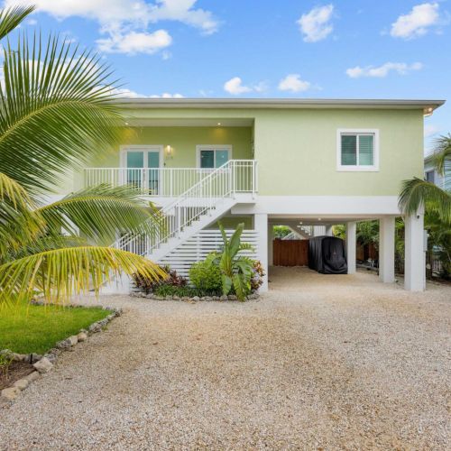 Front exterior: climb the staircase to your elevated retreat with covered parking below.