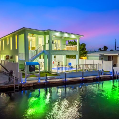 Twilight magic on the canal with illuminated dock lights creating the perfect ambiance for evening cocktails and stargazing from your private waterfront paradise.