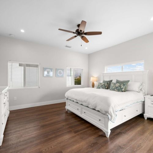 Primary suite: a king bed framed by bright windows, with room to stretch out and unwind.
