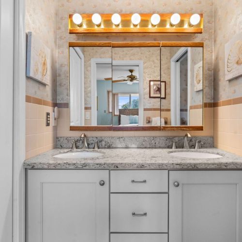 Double vanity, coral accents — beachy elegance built in.