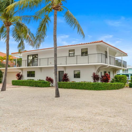 Spacious front driveway with tropical landscaping and wraparound balcony welcoming you to your keys getaway.