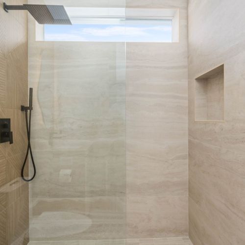 Luxurious walk-in shower with rainfall head and sleek tile, ready to refresh you after sun-soaked days in the keys.