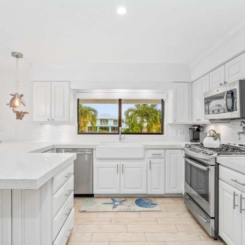 Bright white kitchen with water views and everything you need to cook, snack and hang out.