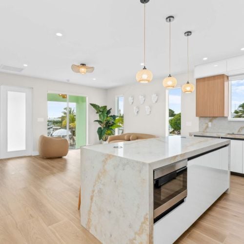 Gourmet kitchen with marble island and open concept living, ideal for gathering with family while preparing fresh keys seafood feasts.