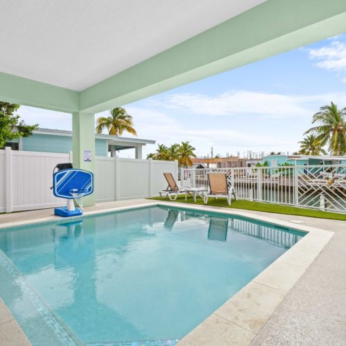 Heated saltwater pool with canal views and covered lounging area, your private slice of paradise for splashing and soaking up the florida keys sunshine.