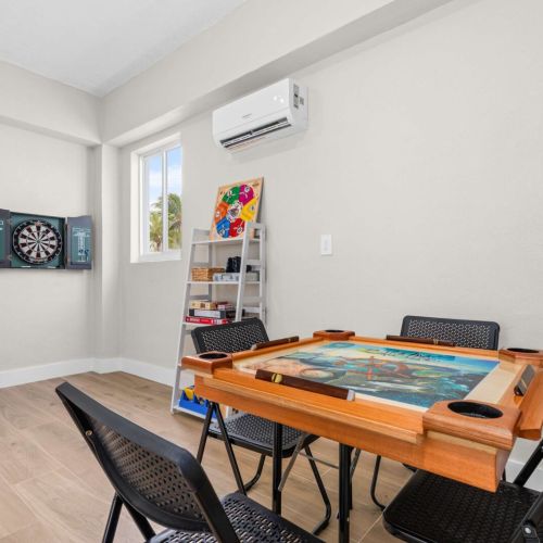 Game room with arcade, darts, and a convertible domino table. Perfect spot for friendly competition and late-night laughs.