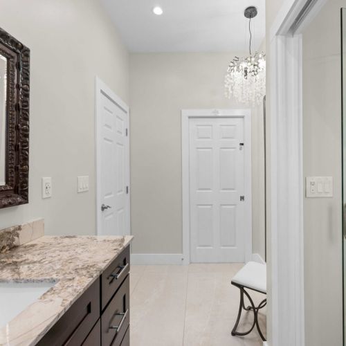 Primary bath: a bright dual-access bath with walk-in shower and chandelier sparkle.