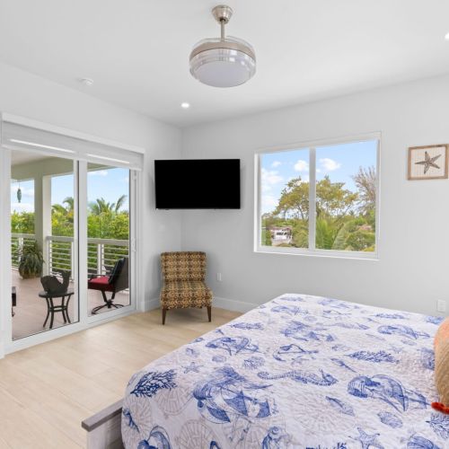 Luxurious and cozy, the second master bedroom offers a king-size bed and stunning balcony views.