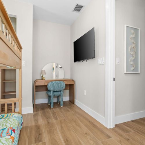 Cozy bunk room with workspace and smart tv, perfect for kids or extra guests to unwind after a day of island fun.