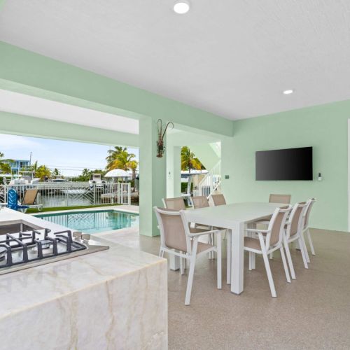 Covered outdoor kitchen and dining area with gas grill, perfect for al fresco meals while soaking in those gorgeous waterfront views.